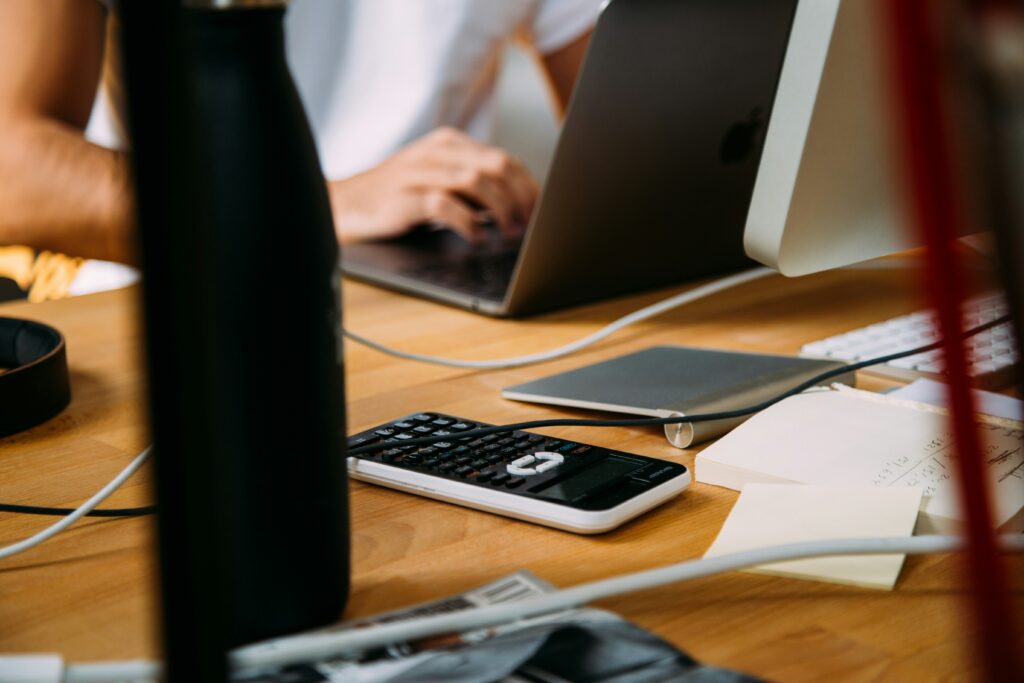 A womans hands at a desk working on a computer